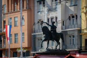 a statue of a man on a horse in front of a building