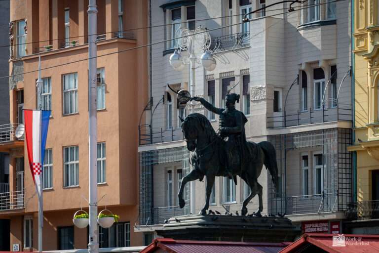a statue of a man on a horse in front of a building