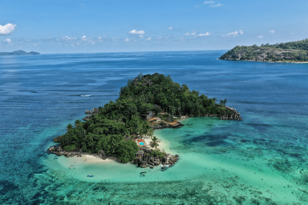 Small tropical Seychelles island surrounded by water