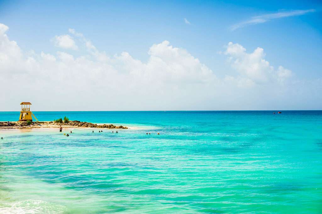 a view of a beach with people swimming in the water