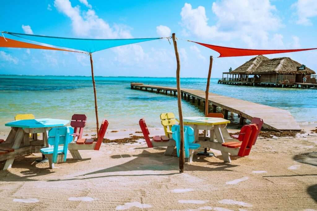 colorful wooden beach lounge chairs and sun shades on a tropical island beachfront