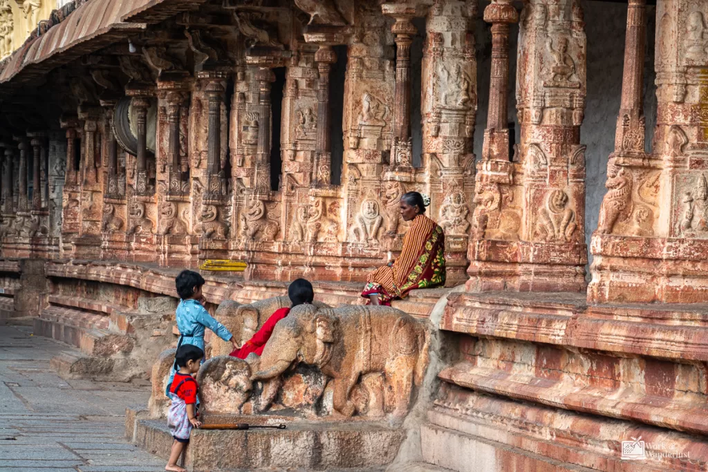 off-the-beaten-path-destinations-hampi-india a group of people sitting on a stone ledge of ruins in Hampi India