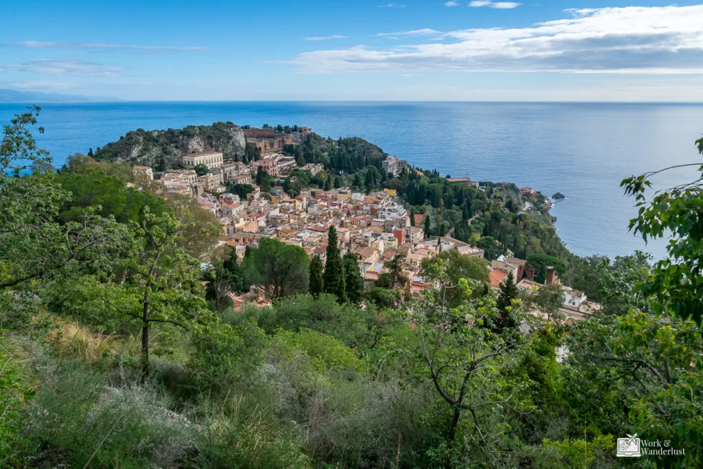 off-the-beaten-path-destinations-taormina-sicily-italy A view of Taormina Sicily in Italy with surrounding water and foliage